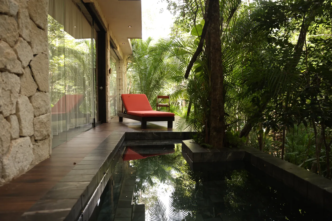 A lounger beside a private plunge pool surrounded by jungle
